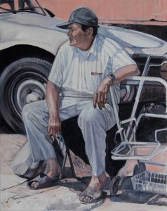 006. Seated man, dressed in white, white car in background